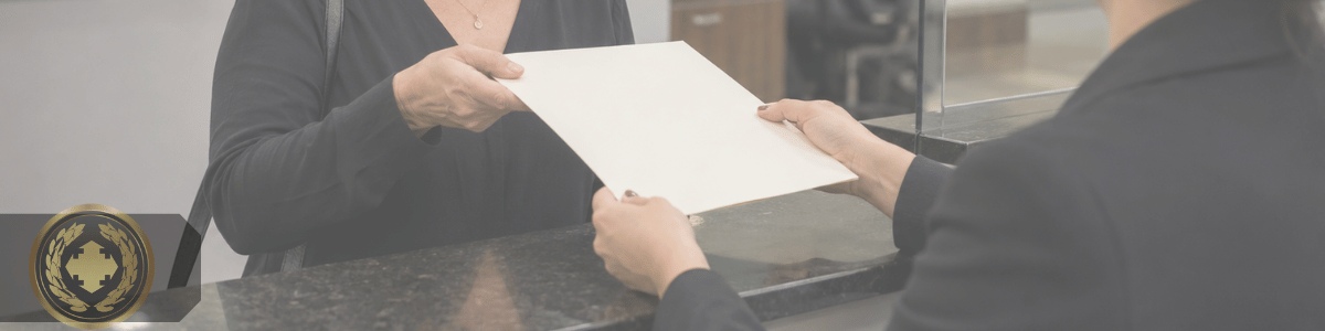 certidão de batismo atualizada para fins matrimoniais Adulto recebendo uma certidão em uma secretaria paroquial, com atendimento acolhedor e ambiente institucional religioso ao fundo.